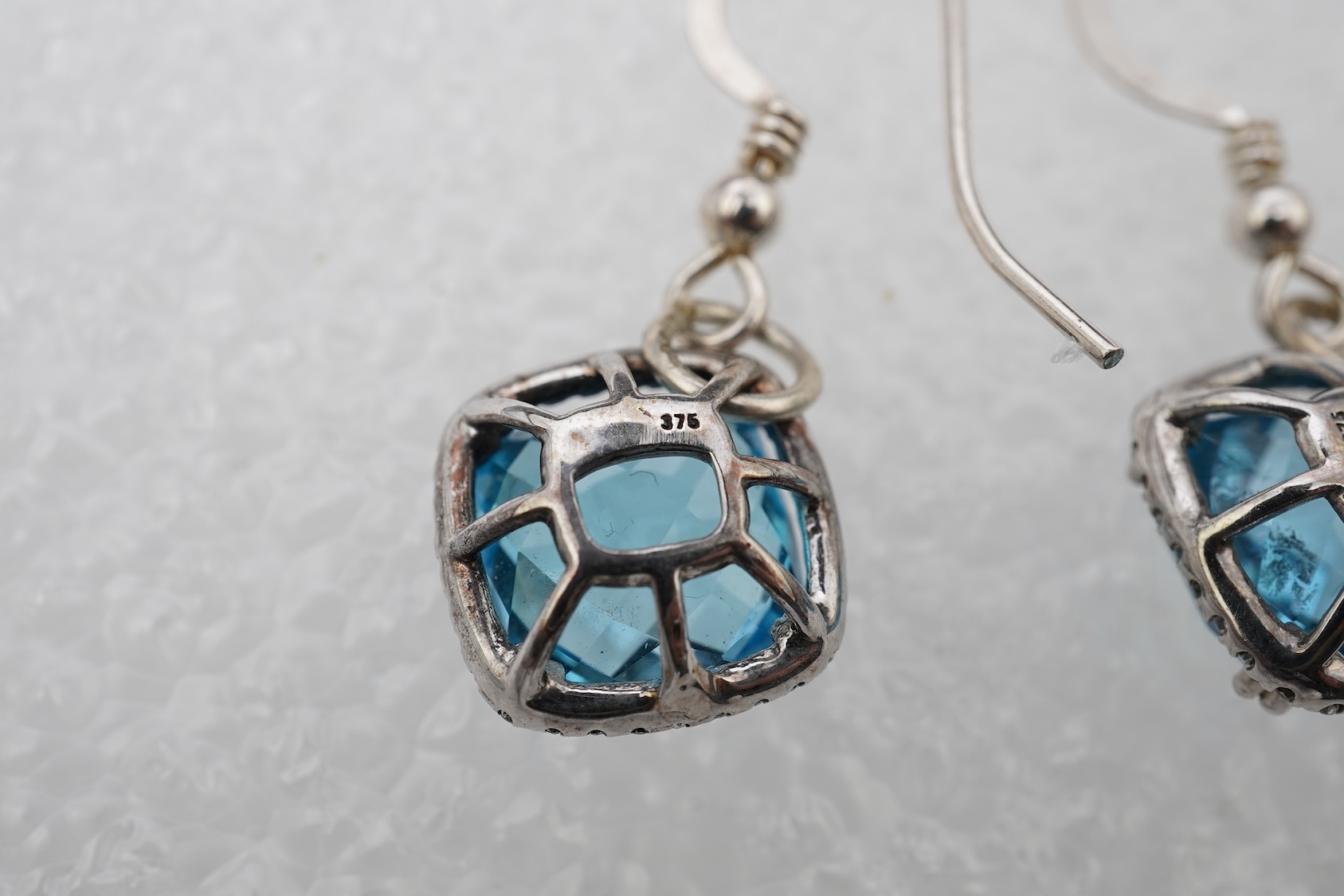 A pair of blue topaz and diamond pendant earrings